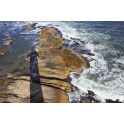 Sombra del faro sobre las rocas